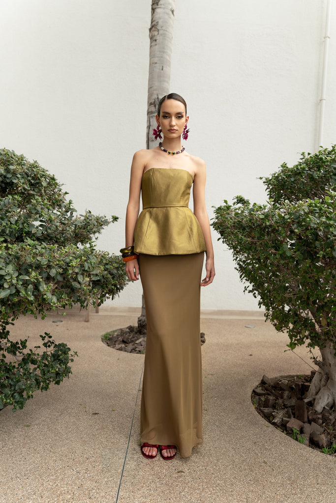 Joanna Economou Designs, @joannaeconomoudesign Cyprus-based fashion designer resort and luxury wear occasion gold strapless gown with refined peplum bodice flowing into floor-length skirt, elegant designer piece for women island Mediterranean-inspired. Shop online from Cyprus worldwide shipping.